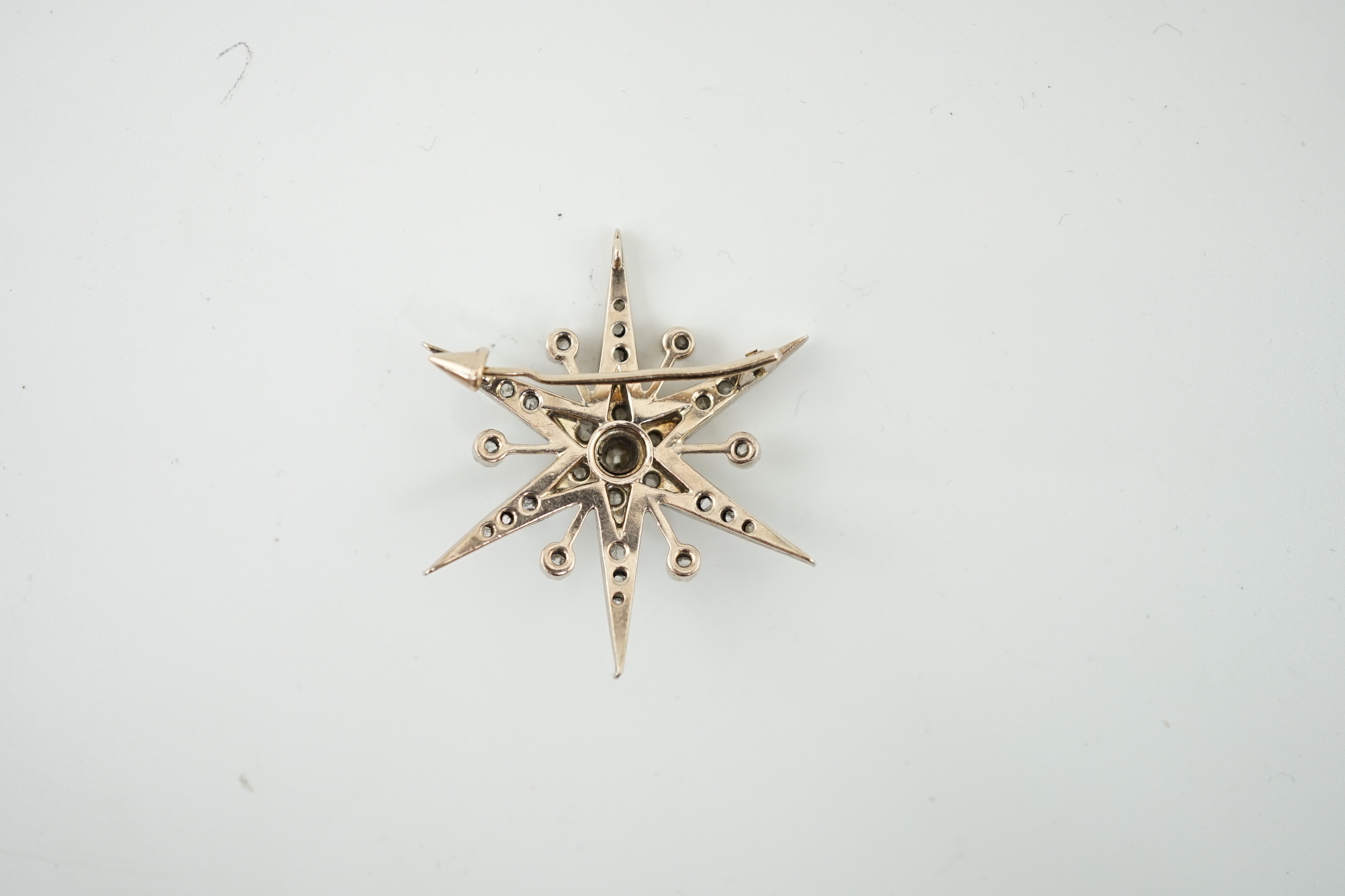 A Victorian style gold, silver and rose cut diamond cluster set starburst brooch
